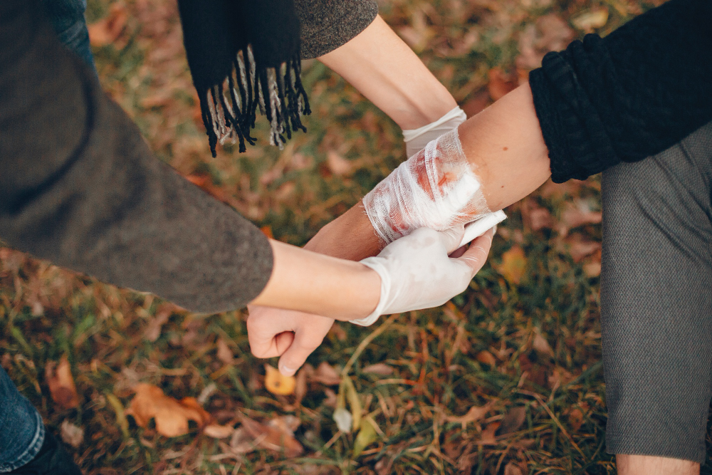 /upl/providing-first-aid-in-the-park-man-bandaged-injured-arm-guy-helps-a-friend.jpg